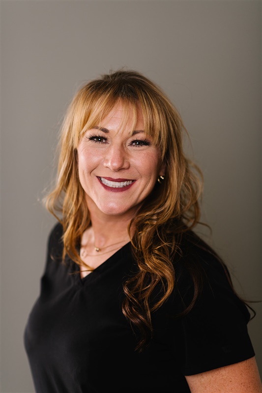 dental hygienist chrissy poses for a portrait photograph wearing black.