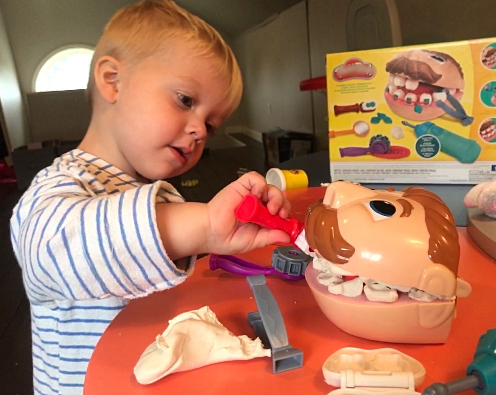 Child playing with Dental Toy kit in play doh