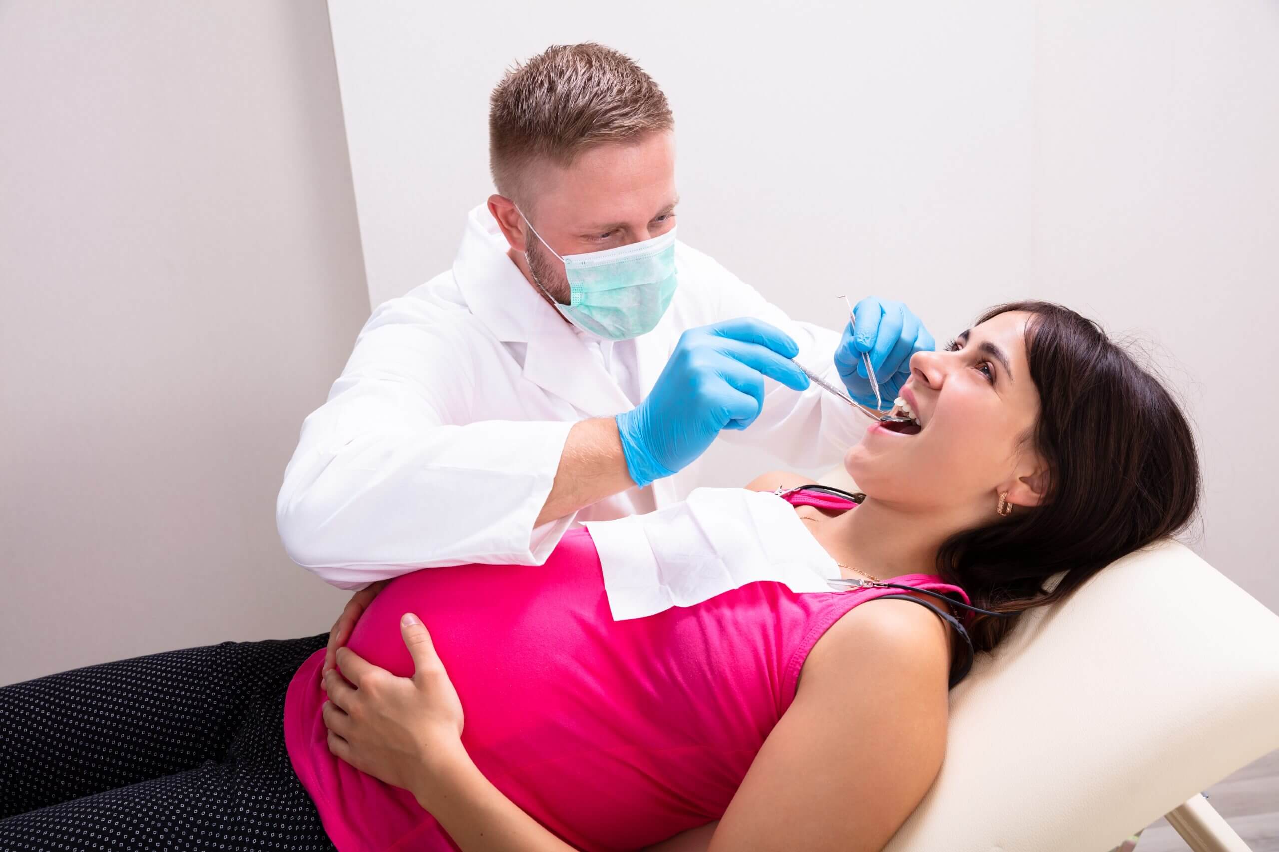 Pregnant Woman getting her teeth examined by a dentist or hygienist
