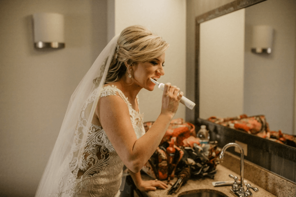 Bride brushing teeth before getting married.